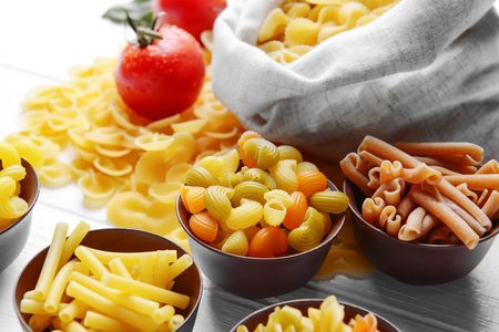 Different kinds of pasta on wooden backgroundの写真素材