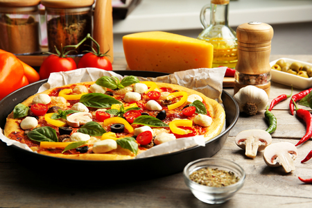 Fresh pizza with tomatoes, cheese and mushrooms on wooden table closeupの写真素材
