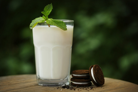Tasty cocktail with mint and cookies on tableの写真素材