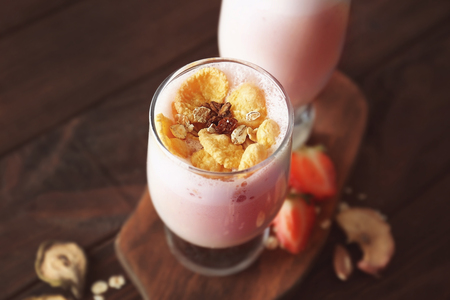 Glasses of delicious milkshake with berries and flakes on wooden board, closeupの写真素材