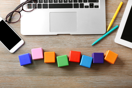 Laptop and wooden cubes on color backgroundの写真素材