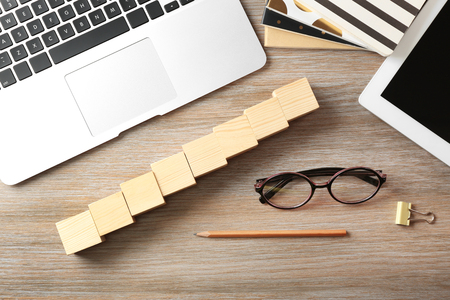 Laptop, copybook and wooden cubes on color backgroundの写真素材