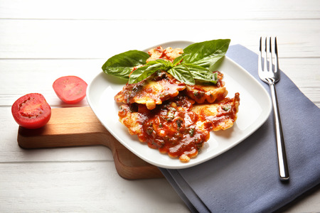 Plate of ravioli with tomato sauce on tableの写真素材