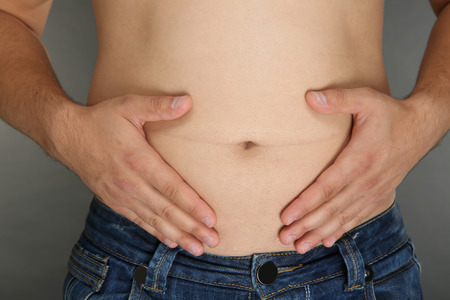 Man touching his fat belly, closeupの写真素材