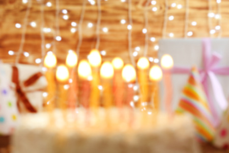 Blurred Birthday cake with candles on lights backgroundの写真素材