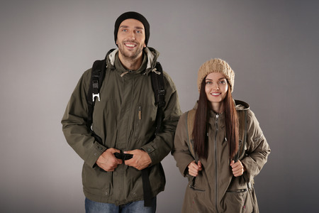Happy couple with luggage on grey backgroundの写真素材