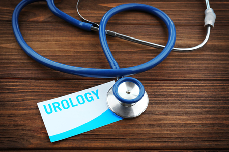 Medical stethoscope and card with word UROLOGY on wooden backgroundの写真素材