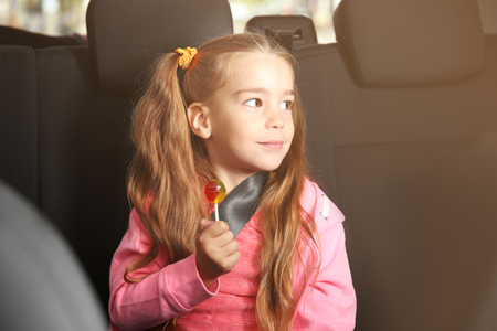 Little girl with lollipop in a carの写真素材