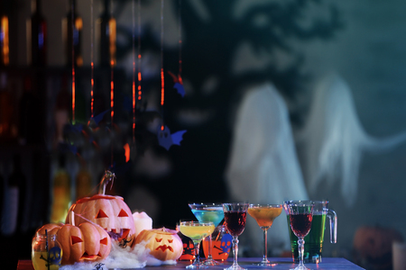 Different colorful cocktails and decor prepared for Halloween party, on blurred backgroundの写真素材