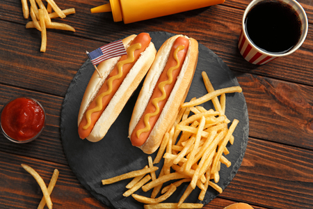 Hot dogs with mustard and small USA flag on slate plateの写真素材