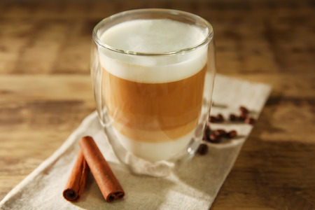 Cup of fresh coffee with cinnamon on wooden backgroundの写真素材