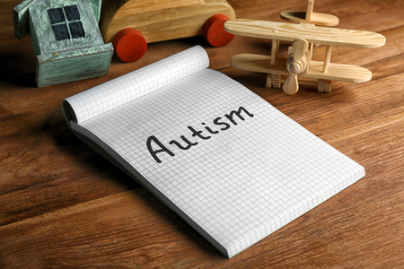 Autism. Word in notebook on wooden backgroundの写真素材