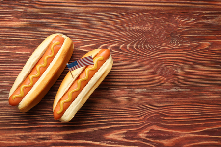 Hot dogs with mustard and small USA flag on wooden backgroundの写真素材