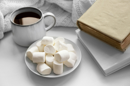 Hot drink with books and marshmallows on windowsillの写真素材