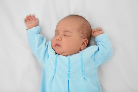 Cute baby sleeping on bed, top viewの写真素材