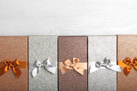 Boxes with Christmas presents on light wooden background