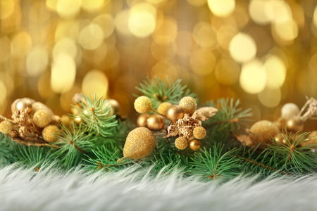 Close up view of Christmas decor and coniferous branches on white fur against defocused lightsの写真素材