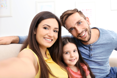 Happy family taking selfie at homeの写真素材