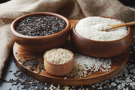 Different types of rice in bowls on grey table closeupの写真素材