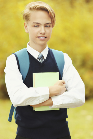 Handsome teenager with book in parkの写真素材