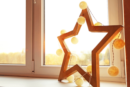 Beautiful decorative star with garland on window sillの写真素材