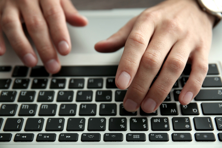 Businessman using laptop, close up