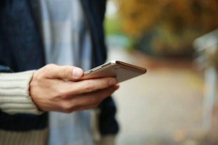 Man using smart phone outdoorsの写真素材