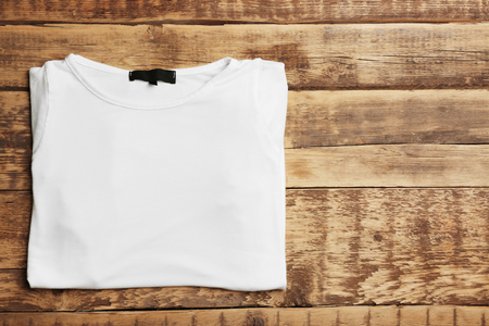 Blank white t-shirt on wooden backgroundの写真素材