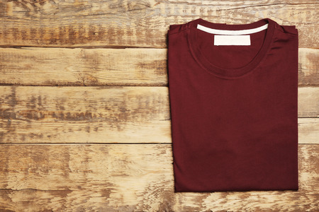 Blank maroon t-shirt on wooden backgroundの写真素材