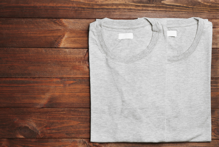 Blank light grey t-shirts on wooden backgroundの写真素材