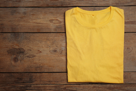 Blank yellow t-shirt on wooden backgroundの写真素材