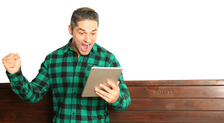 Handsome young man using tablet on wall backgroundの写真素材