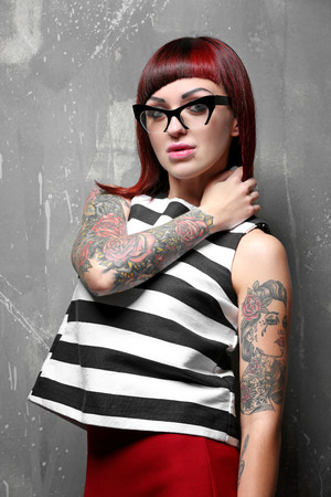 Beautiful girl with tattoo on color backgroundの写真素材