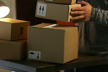 Deliverer holding carton boxes, closeupの写真素材