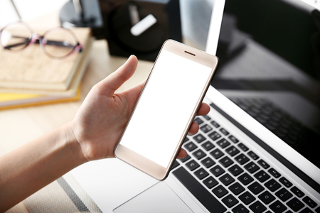 Woman with laptop and cellphone at homeの写真素材
