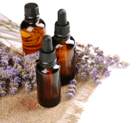 Bottles with essential oil and lavender on white backgroundの写真素材