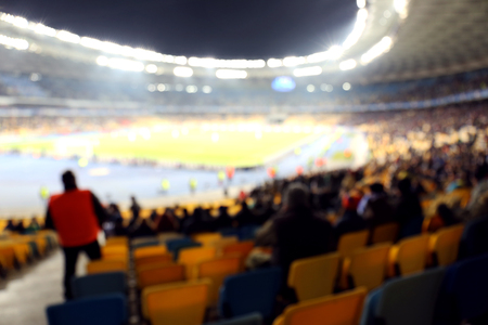 Fans watching football game at stadium, blurred backgroundの写真素材
