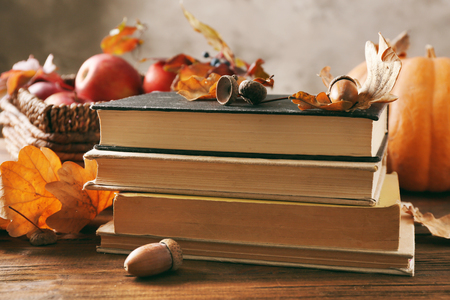 Beautiful autumn composition with pile of books on wooden backgroundの写真素材