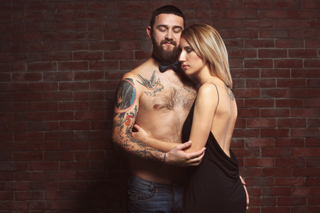 Fashion tattooed  couple on brick wall backgroundの写真素材