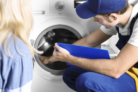 Plumber repairing washing machineの写真素材