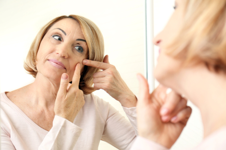 Senior woman near mirrorの写真素材