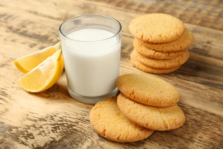 Lemon cookies with milk on wooden background
