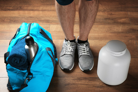 Male legs and sport bag on the floorの写真素材