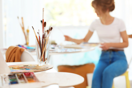 Glass with brushes and palette on white table, close up viewの写真素材
