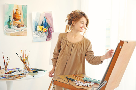 Young female artist painting picture in studioの写真素材