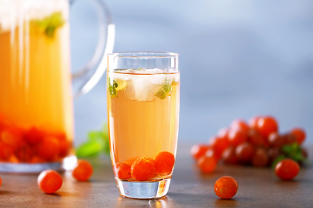 Cold grape cocktail and fresh berries on blurred backgroundの写真素材