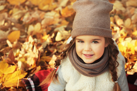 Cute little girl in beautiful autumn parkの写真素材