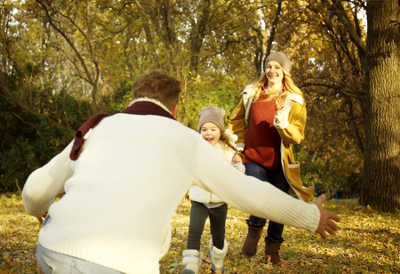 Happy family having fun in beautiful autumn parkの写真素材