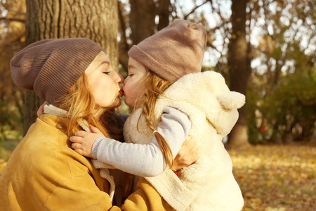 Mother and daughter hugging in beautiful autumn parkの写真素材