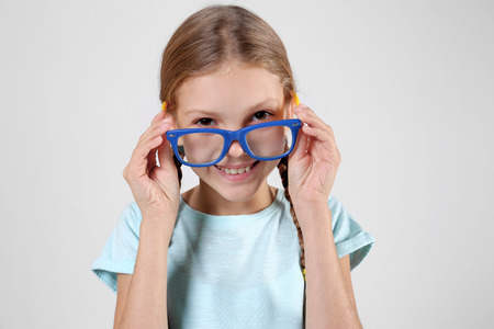 Little girl with spectacles on light backgroundの写真素材